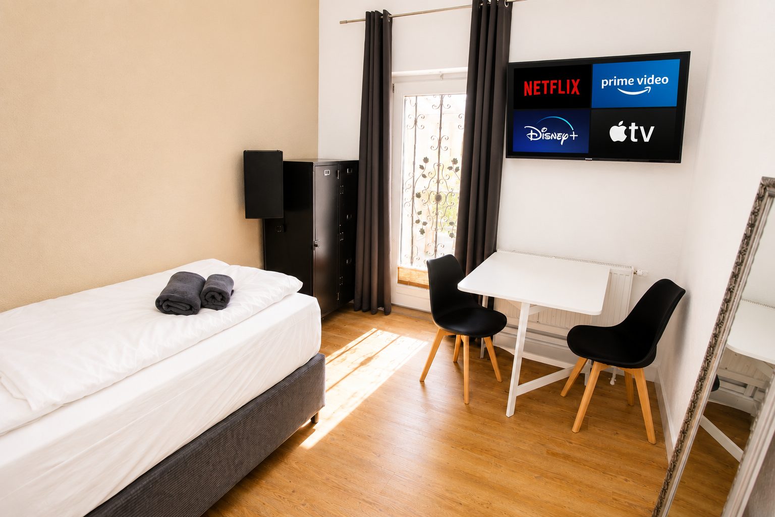 Zimmer der Monteurvilla Euskirchen mit Einzelbett, Klapptisch und zwei Stühlen